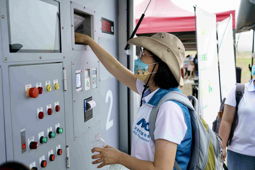 志工們將拾起的寶特瓶投入「好歸塑專車」，讓廢棄塑料空瓶可以直接粉碎、縮小體積，未來將可再製成購物袋、寶特衣、悠遊卡等生活用品